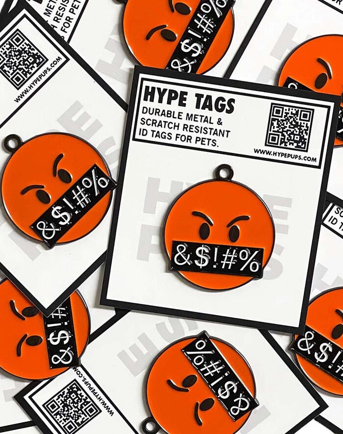 Multiple orange angry face dog tags with Hype Tags packaging showing product details