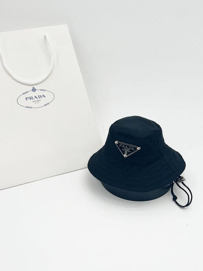 Black Pawda triangle logo bucket hat with adjustable chin strap and Prada shopping bag