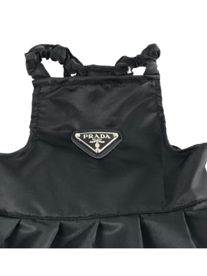 Close-up of black nylon dog dress showing Prada triangle logo detail and construction