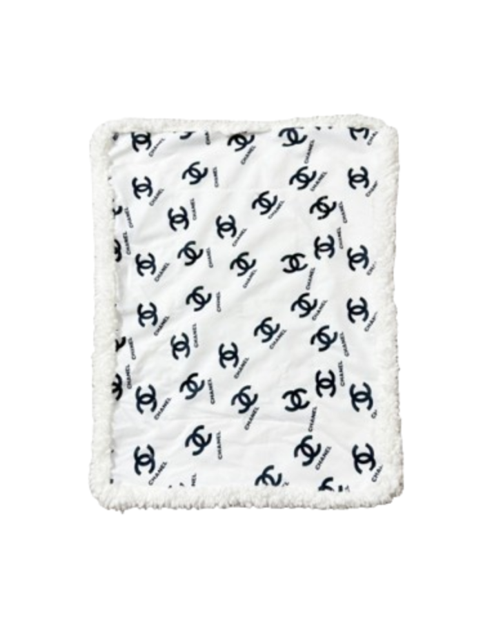 White and black Chanel inspired dog bed with interlocking logo pattern and plush sherpa border trim