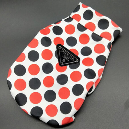 White polka dot dog jacket flat lay showing Pawda triangle logo and zip closure