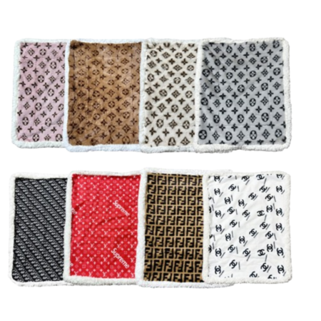 Designer dog bed collection showing 8 different parody brand patterns including Louis Vuitton, Supreme, Chanel and Fendi inspired designs with white sherpa borders