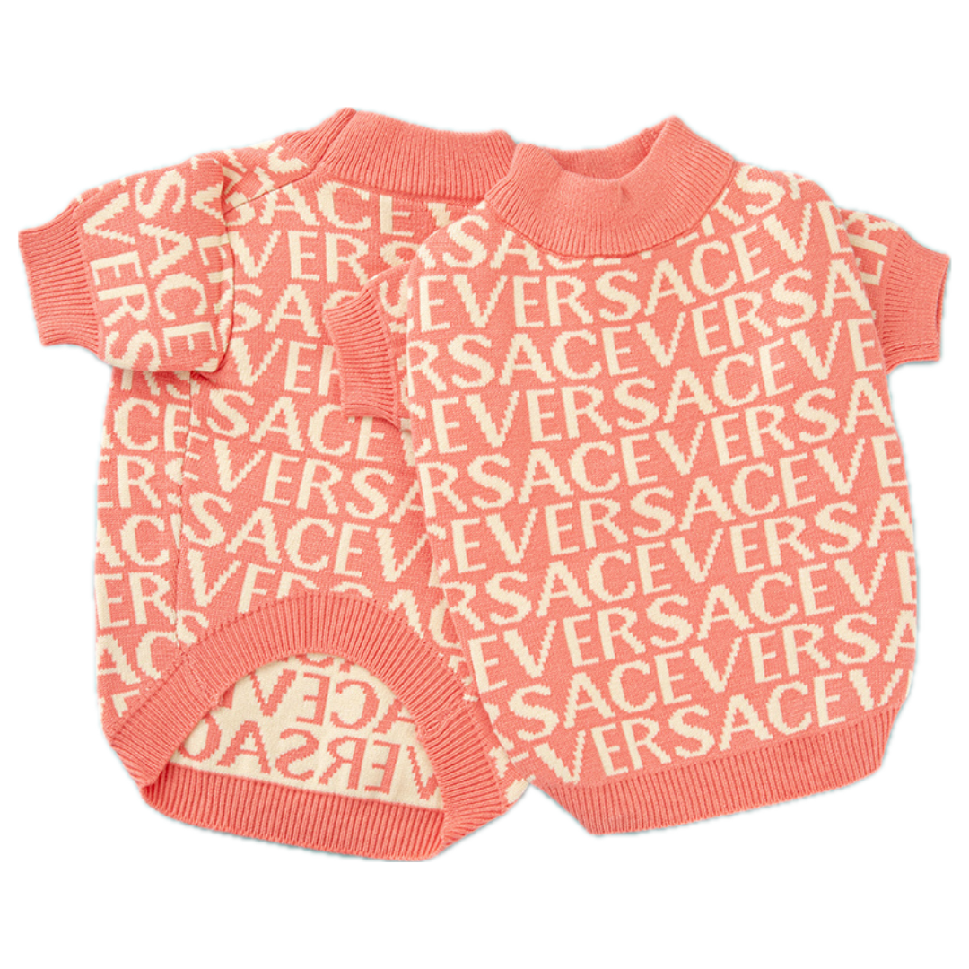 Flat lay of coral knit dog sweater with repeating Versace lettering design