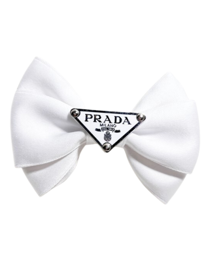 White satin dog hair bow with Prada triangle logo detail on white background