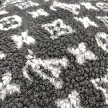 Close-up of charcoal fleece fabric with white V monogram pattern dog bed texture