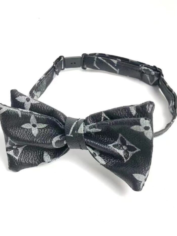 Black monogram bow tie with V pattern and adjustable collar strap closeup