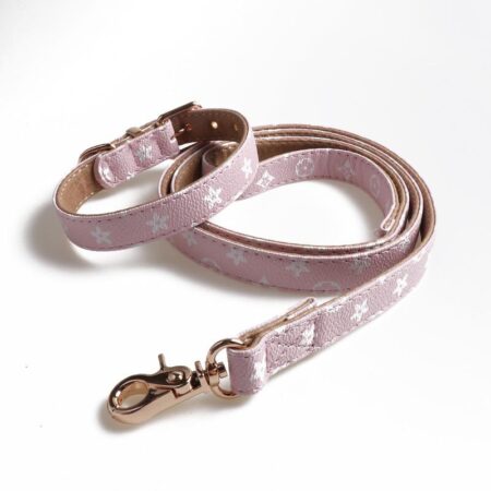 Pink faux leather dog collar and leash with V monogram pattern on white background