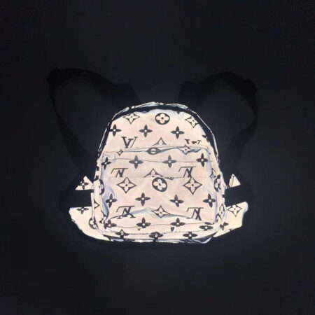 Reflective dog backpack with V monogram pattern showing adjustable straps and buckles